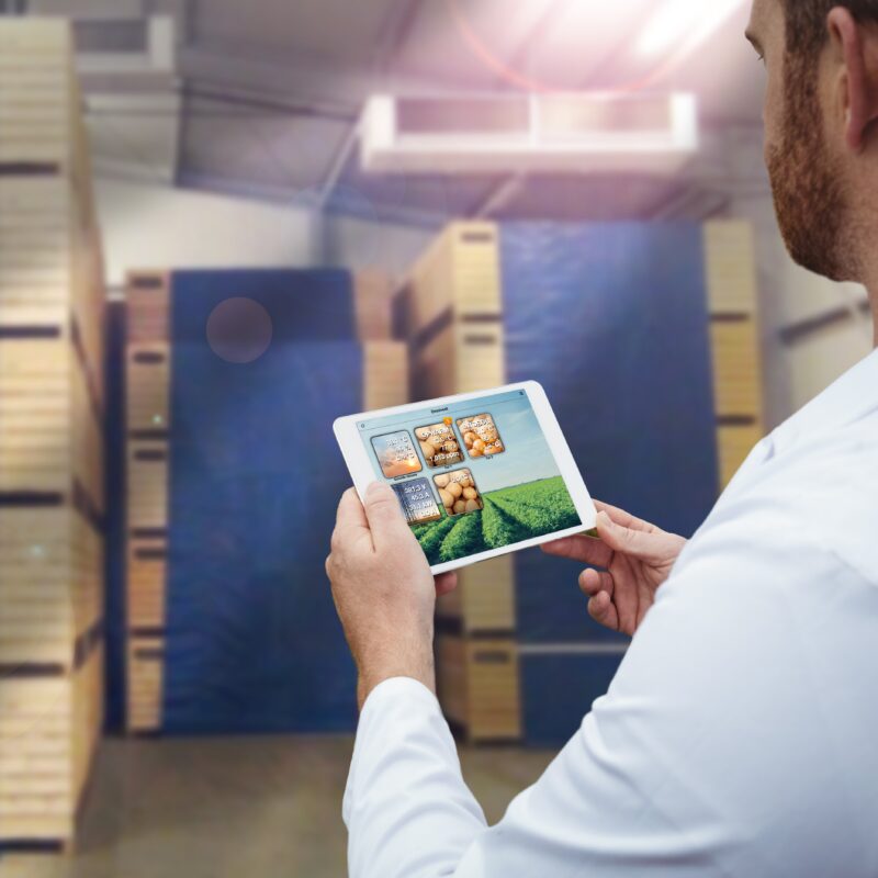 Smiling worker holding his digital tablet in a large warehouse